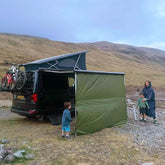 Family enjoying outdoor camping near a campervan with bikes, featuring the DD Hammocks Campervan Tarp for shade.